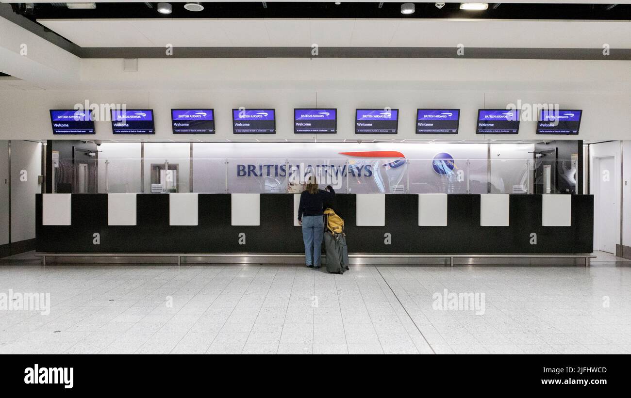 Eine Frau erkundigt sich an einem fast leeren Schalter von British Airways am London Heathrow Terminal 3. Bild aufgenommen am 25.. Juni 2022. © Belinda Jiao jiao.bilin@gm Stockfoto