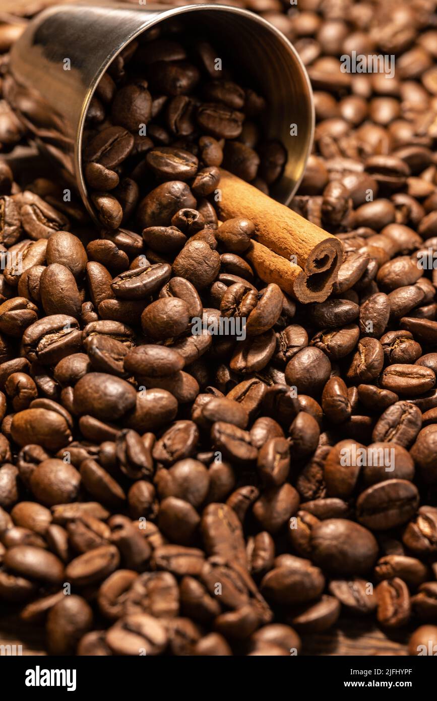 Vollen Eimer und Ausschlag in der Nähe eines Eimers Kaffeebohnen mit Zimtstange Stockfoto