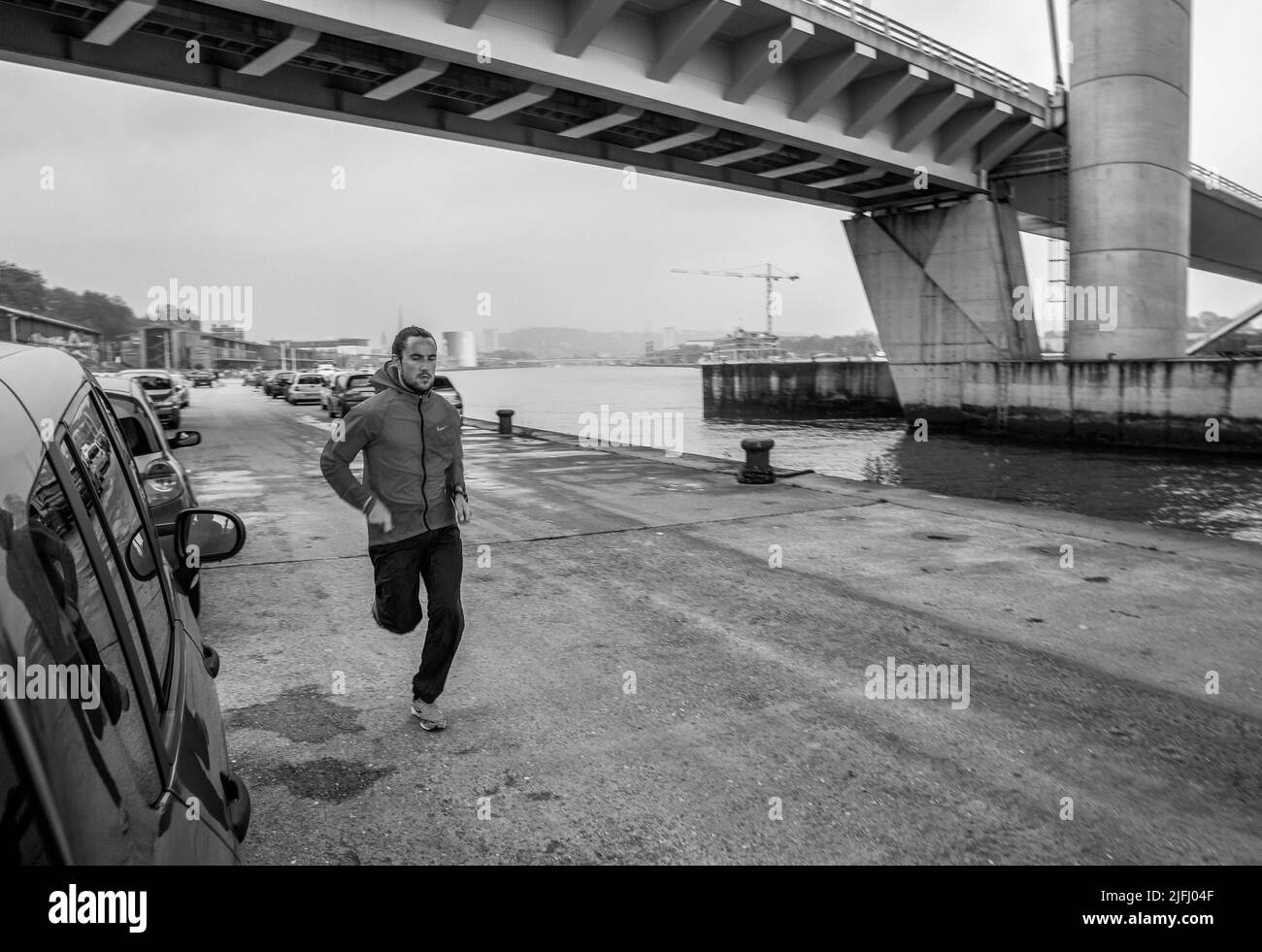 05-12-2016 Ein junger Mann läuft (trainiert) in Sportkleidung unter der Gustav Flauberay Brücke ein wenig neblig, neben der seine Stockfoto