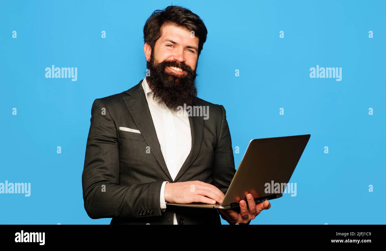 Lächelnder Geschäftsmann arbeitet mit einem Laptop oder Notebook. Büro, Unternehmen, Technologie, Internet. Stockfoto