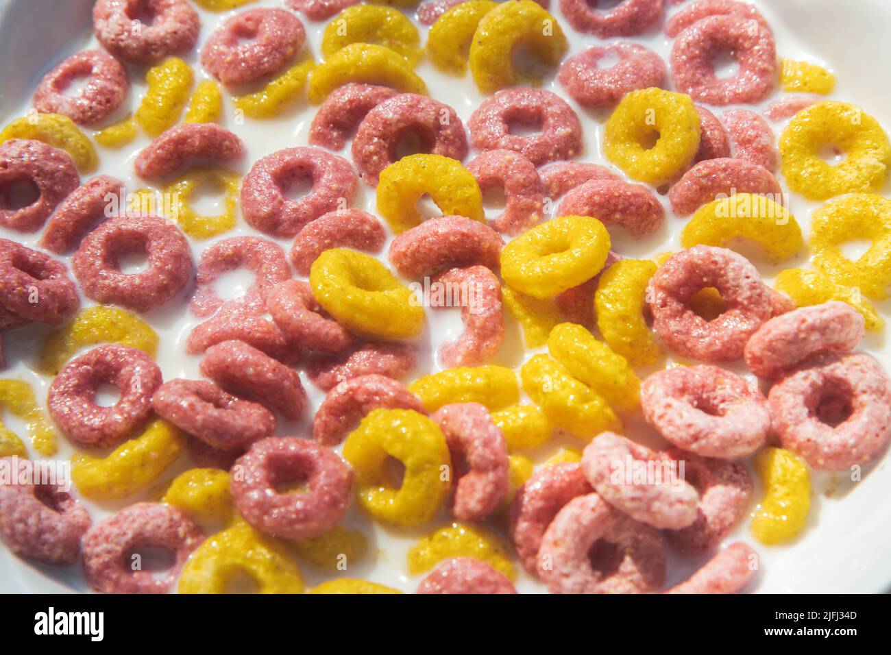Trockenes Frühstück für Kinder, gefüllt mit Milch auf einem Teller Stockfoto