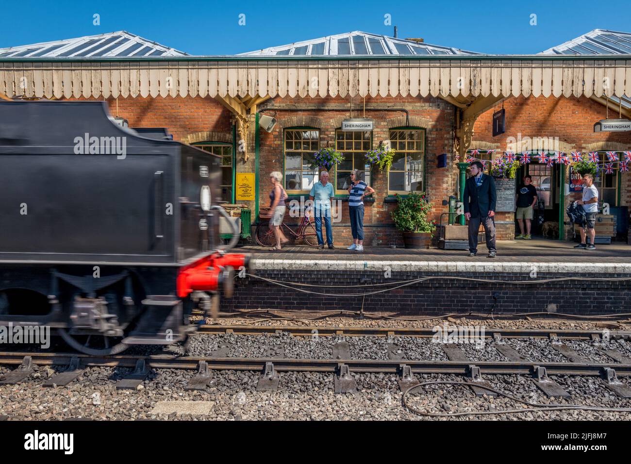 Passagiere und Touristen auf dem Bahnsteig am historischen Bahnhof von Sheringham, der Teil der North Norfolk-Eisenbahn ist. Stockfoto