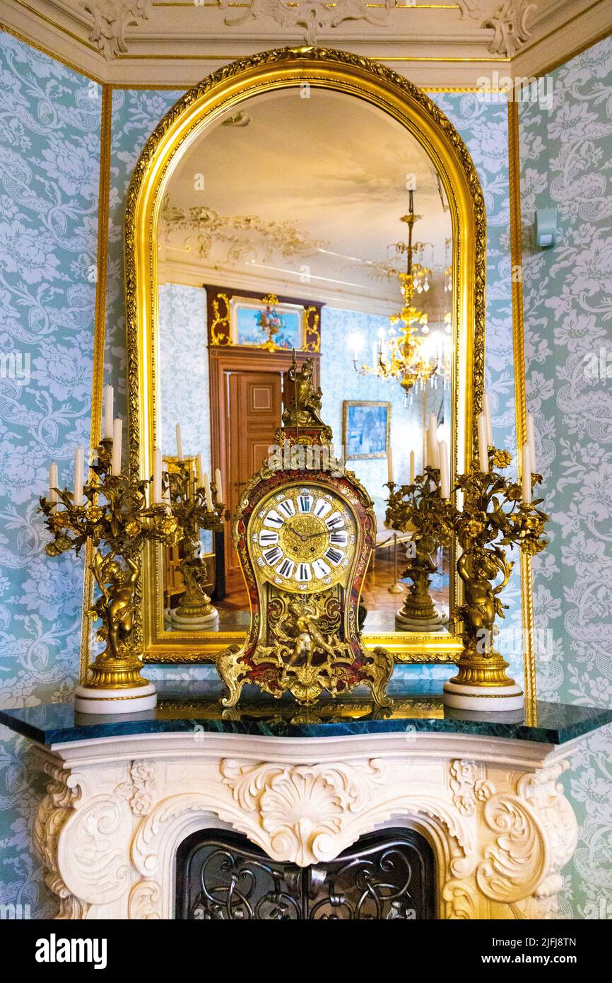 Kunstvolle goldene Uhr, Spiegel und Kamin im Herbst Palace Museum (Muzeum Pałac Herbsta), Lodz, Polen Stockfoto