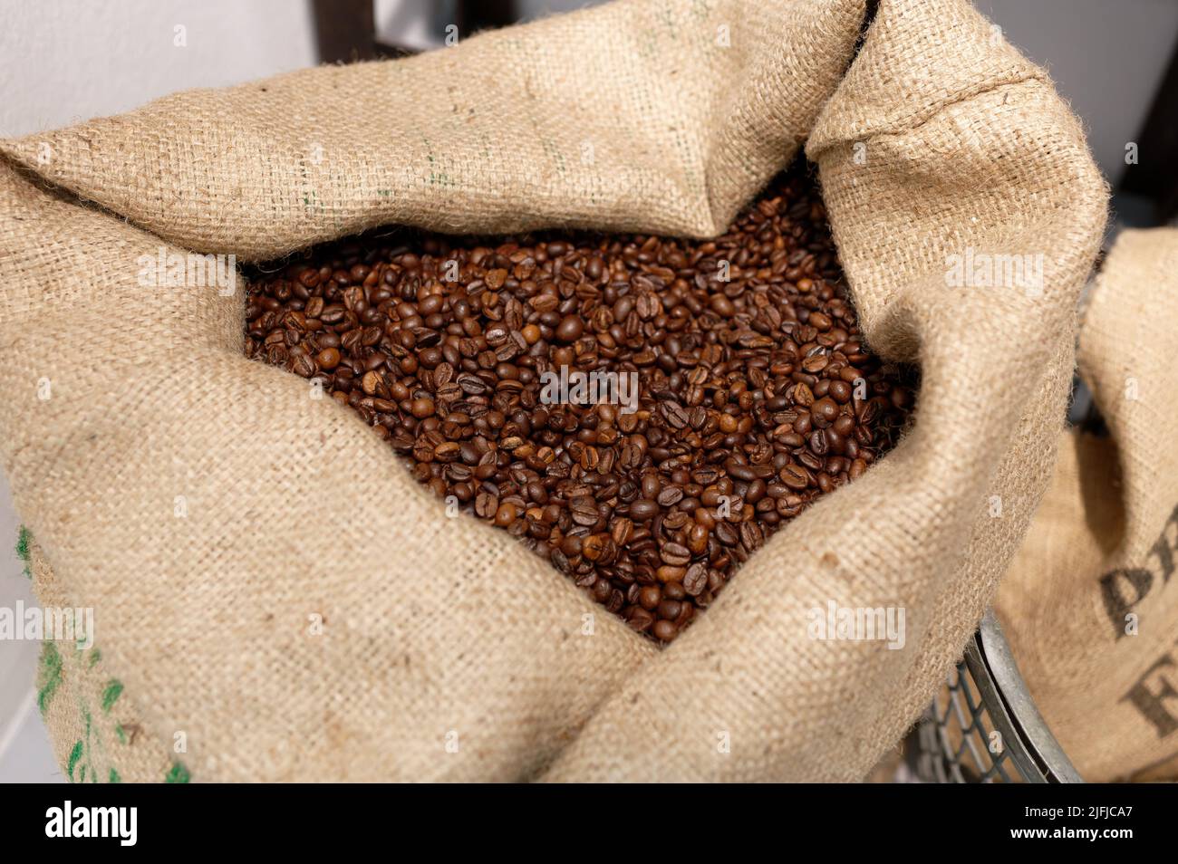 Ein offener Jutebeutel mit gerösteten Kaffeebohnen Stockfoto