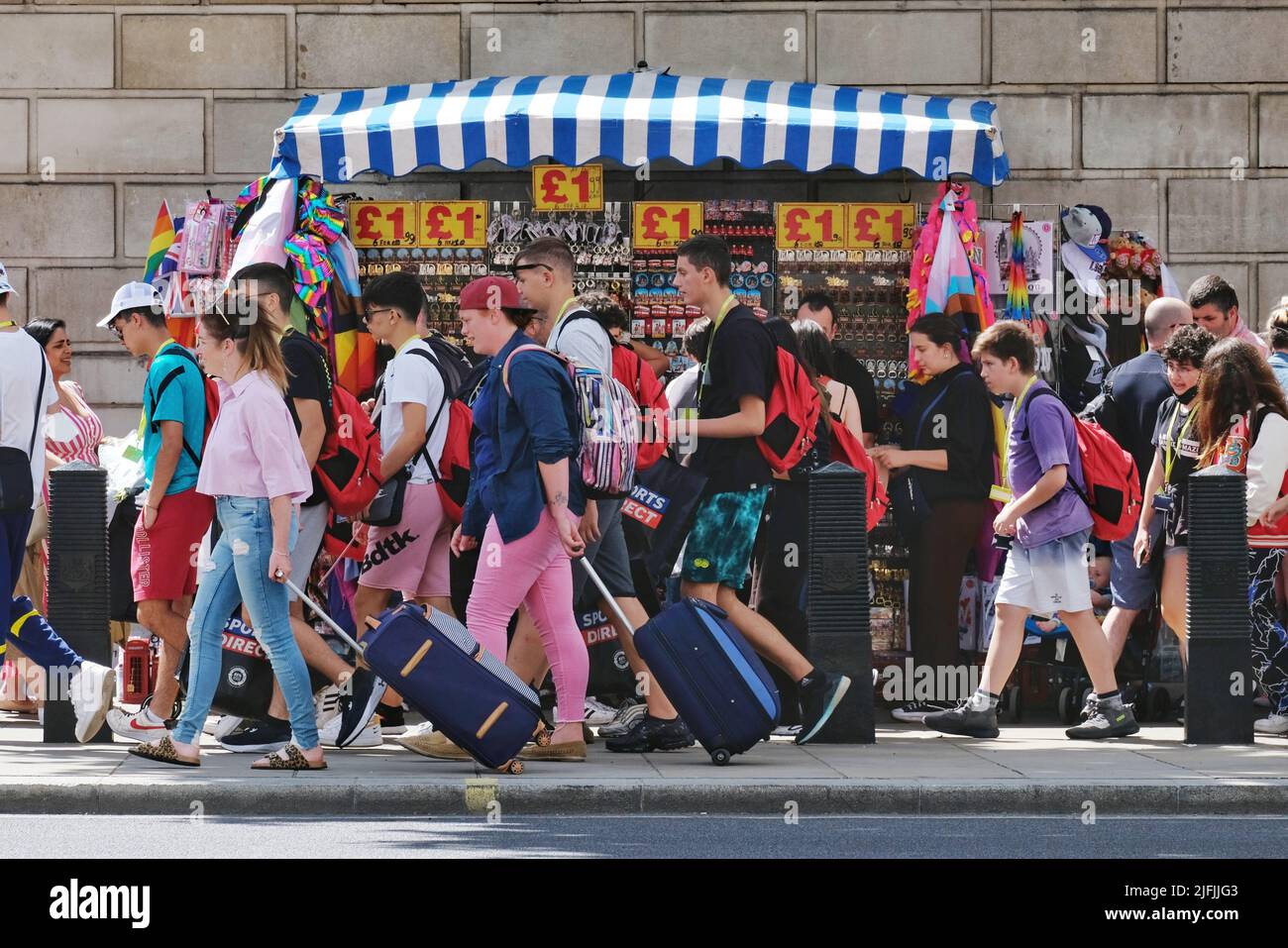 London, Großbritannien. Touristen, einige mit Koffern, kommen an einem Souvenirstand in Whitehall vorbei, da eine geschäftige Sommersaison beginnt. Stockfoto