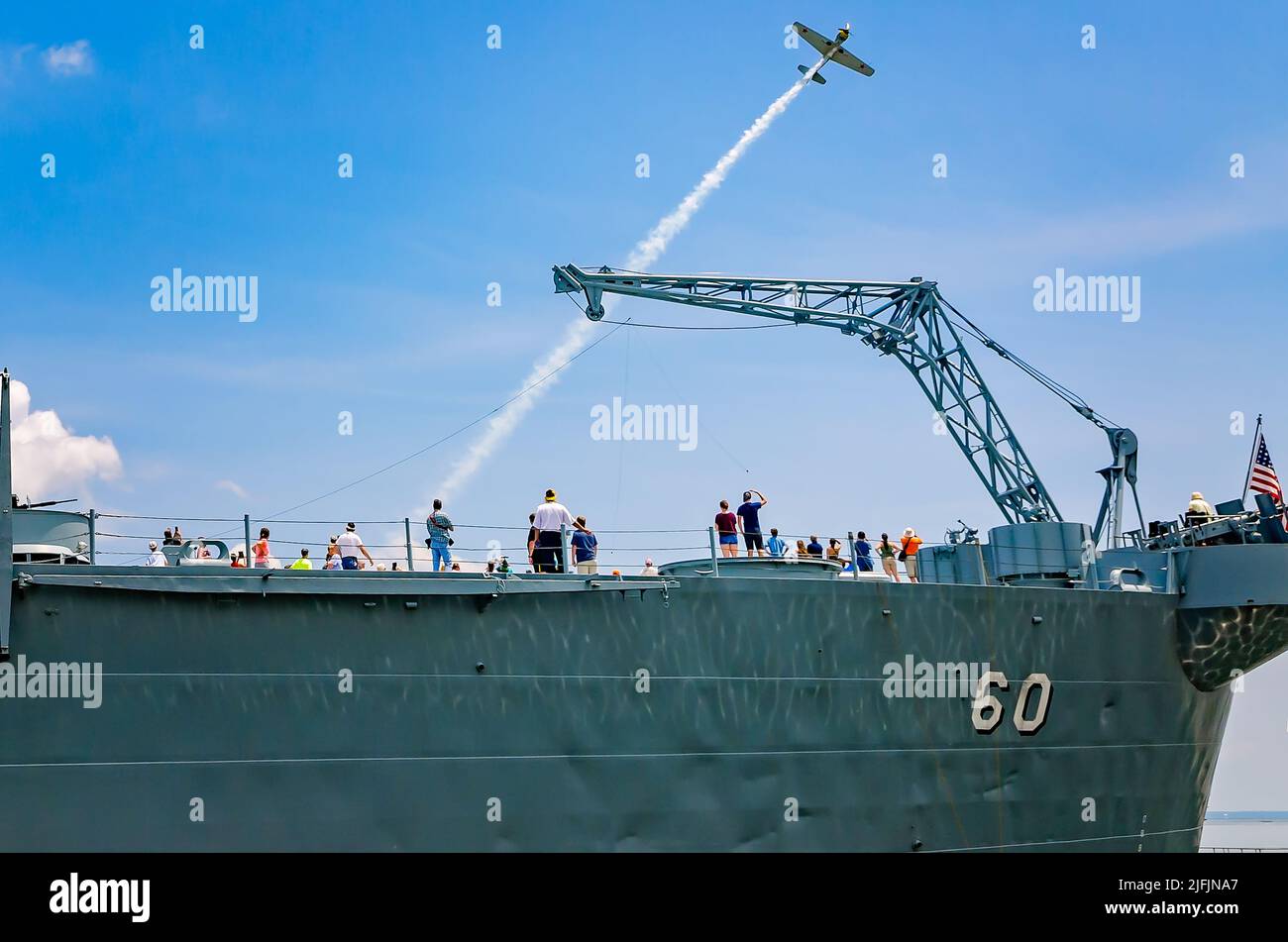 Am 12. August 2017 wird im Battleship Memorial Park in Mobile, Alabama, das Deck der USS Alabama von Menschen erkundet, während ein altes Kampfflugzeug überfliegt. Stockfoto