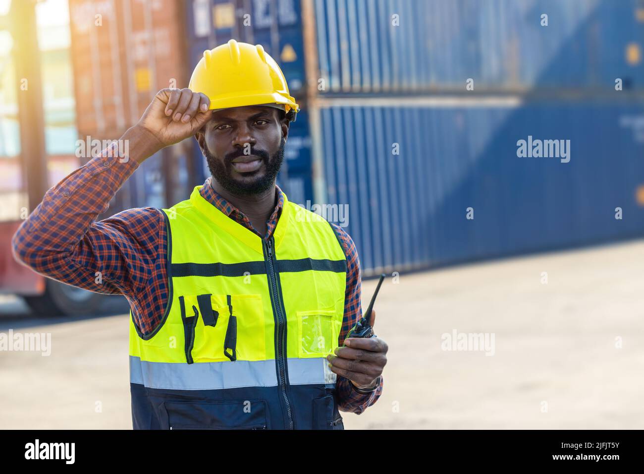 Portrait intelligenter, selbstbewusster Vorarbeiter für schwarze Arbeiter in der Hafenfrachtcontainer-Schifffahrt. Stockfoto