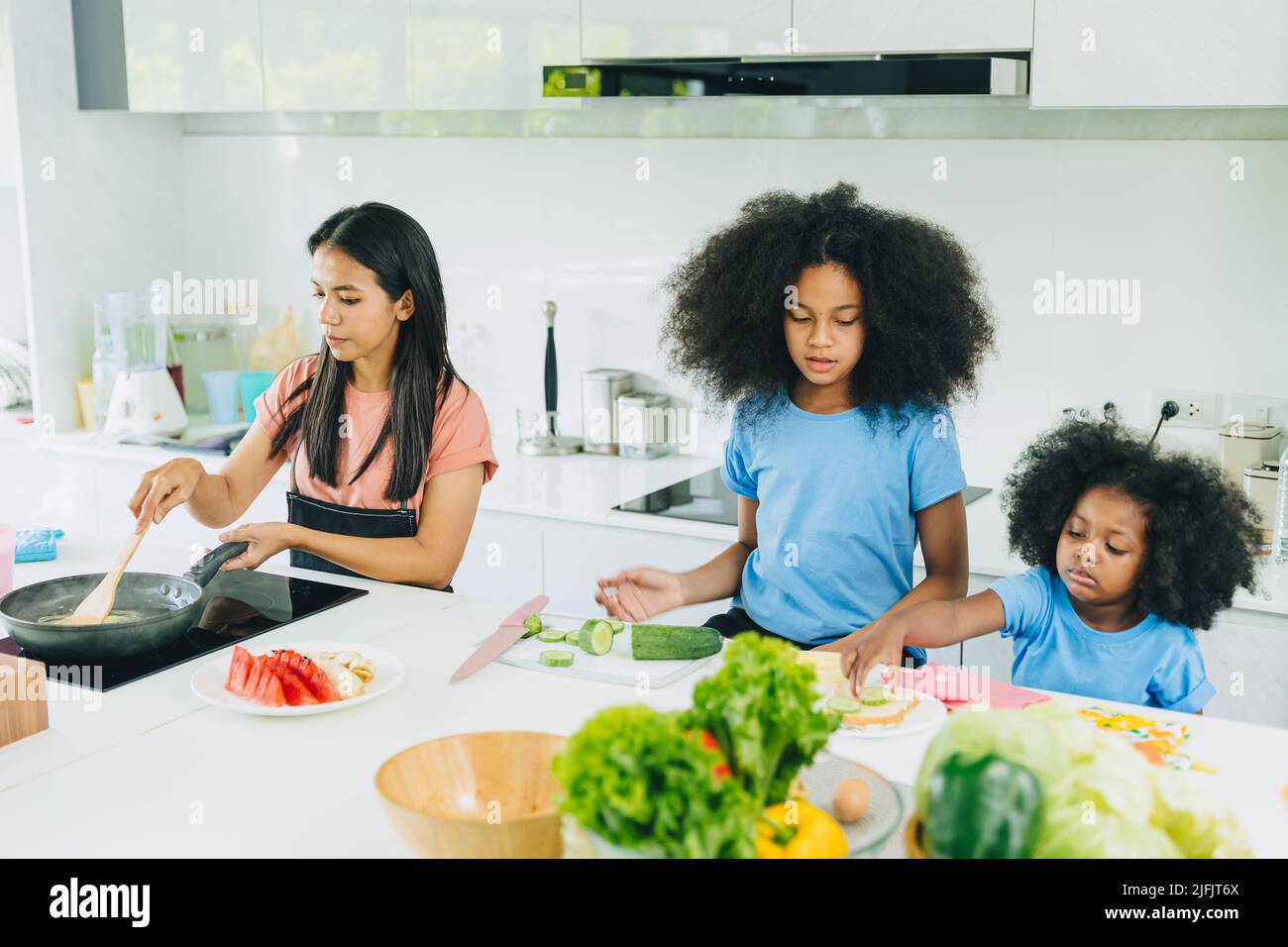 Mama mit Kindern kochen gesunde Lebensmittel zu Hause Küche Aktivität Urlaub. Stockfoto