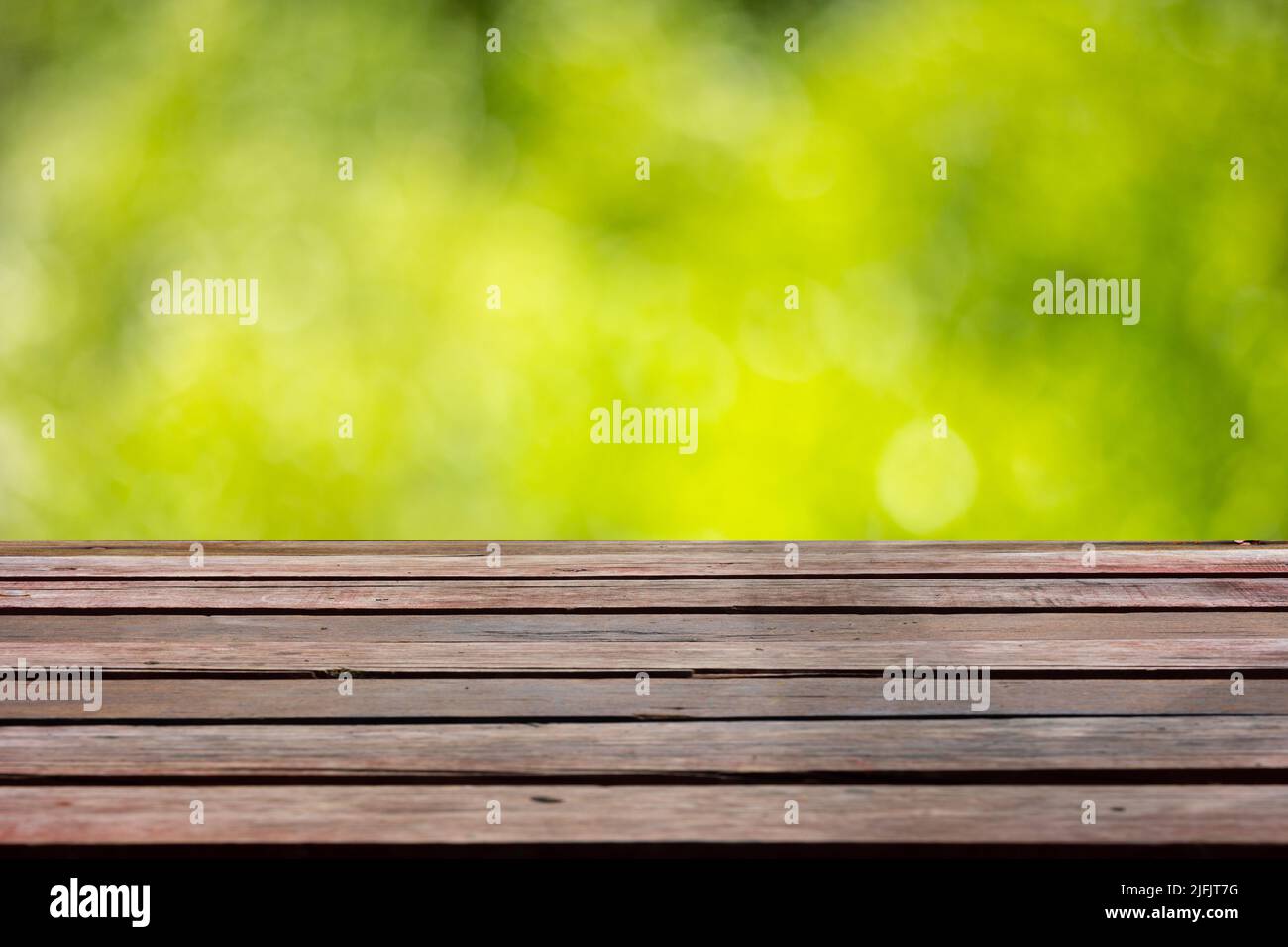 Holztischplatte auf weichem hellgrünen Bokeh für Montageprodukte zeigen Öko natürlichen Hintergrund Stockfoto