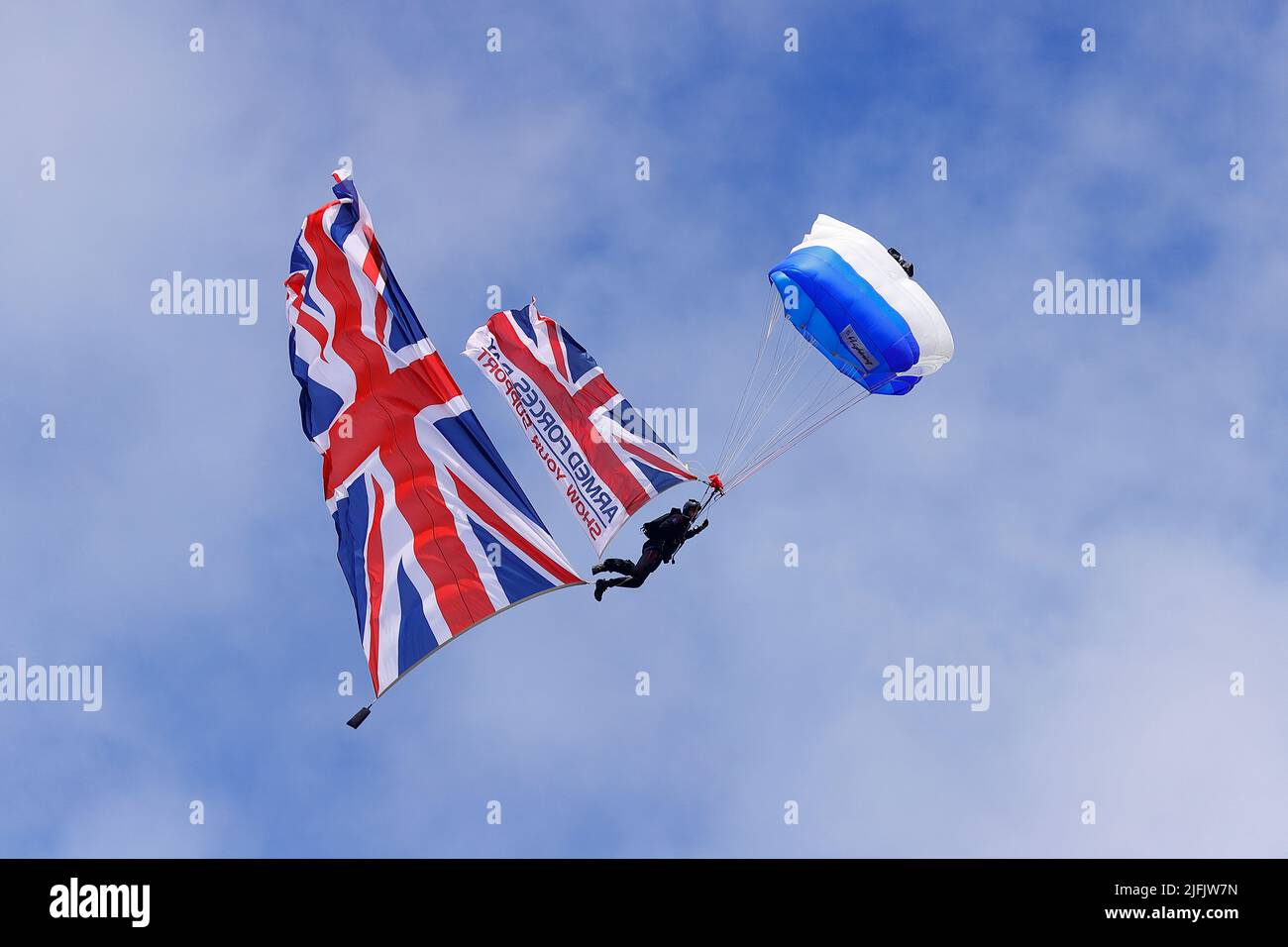 Ein Fallschirmspringer vom Wings Fallschirmspringer-Display-Team geht mit der Flagge des Armed Forces Day im Pontefract Park zum Wakefield Armed Forces Day Stockfoto