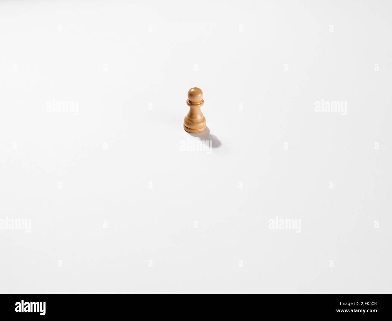 Eine weiße Schachfigur aus Holz auf weißem Hintergrund. Stockfoto