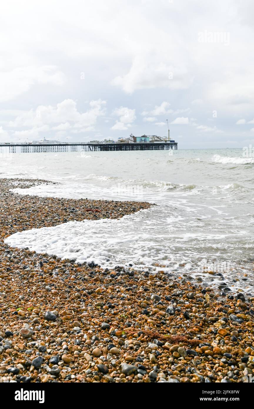 Brighton UK - Brighton Beach mit Palace Pier im Hintergrund entlang der Ostküste von Sussex Stockfoto