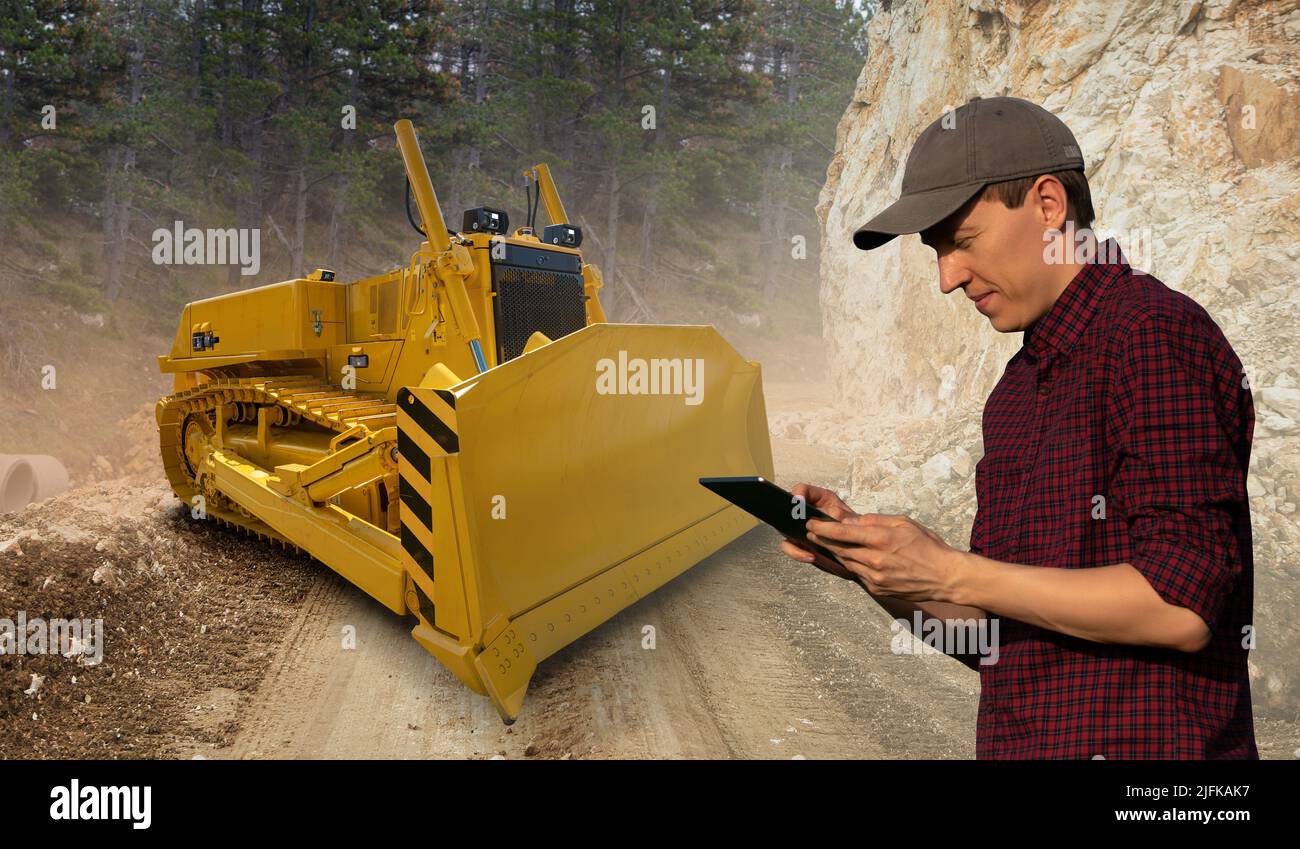Ingenieur Programme autonomen Bulldozer mit digitalen Tablet Stockfoto
