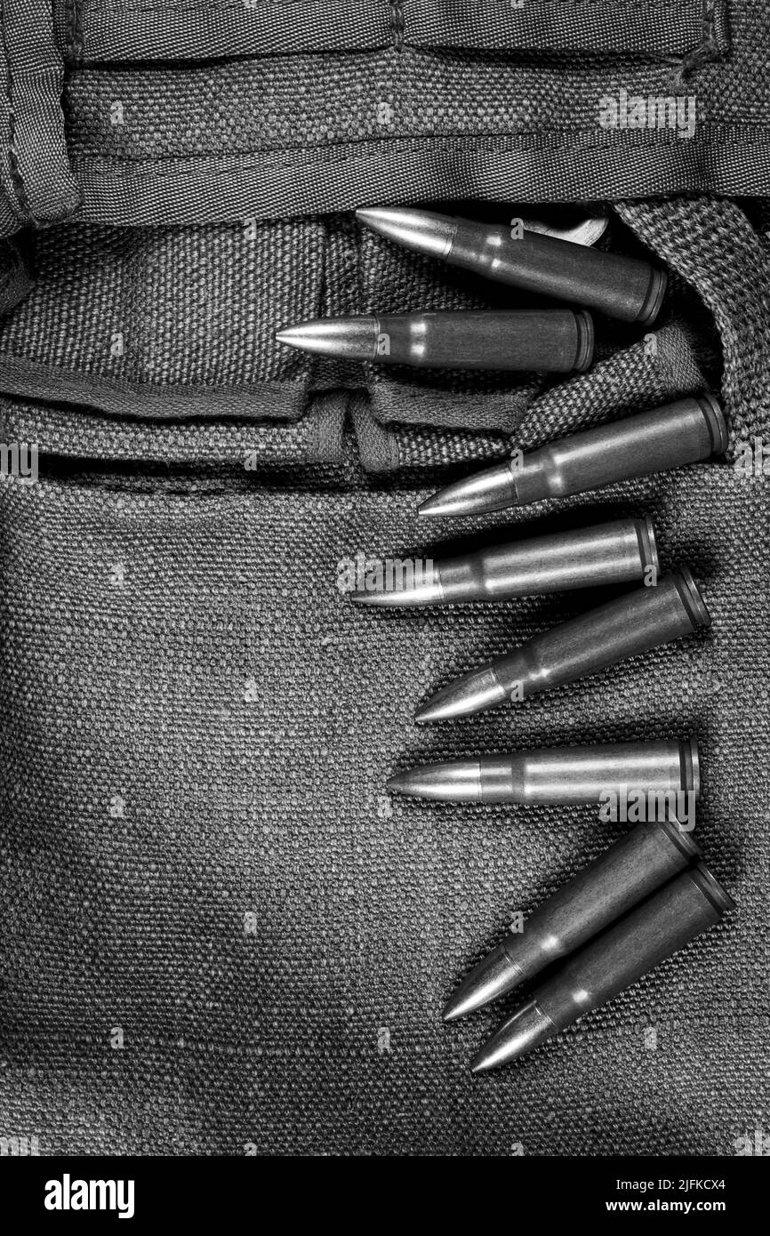 AK-47 auf einem Stück militärischer Leinwand liegende Munitionsmunition, monochromes Foto Stockfoto