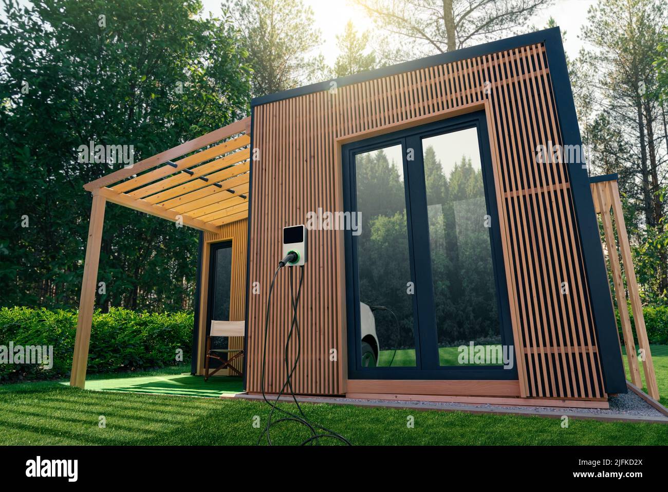 Holzhaus im Wald mit einer Ladestation für Elektroautos an der Wand. Konzept Stockfoto