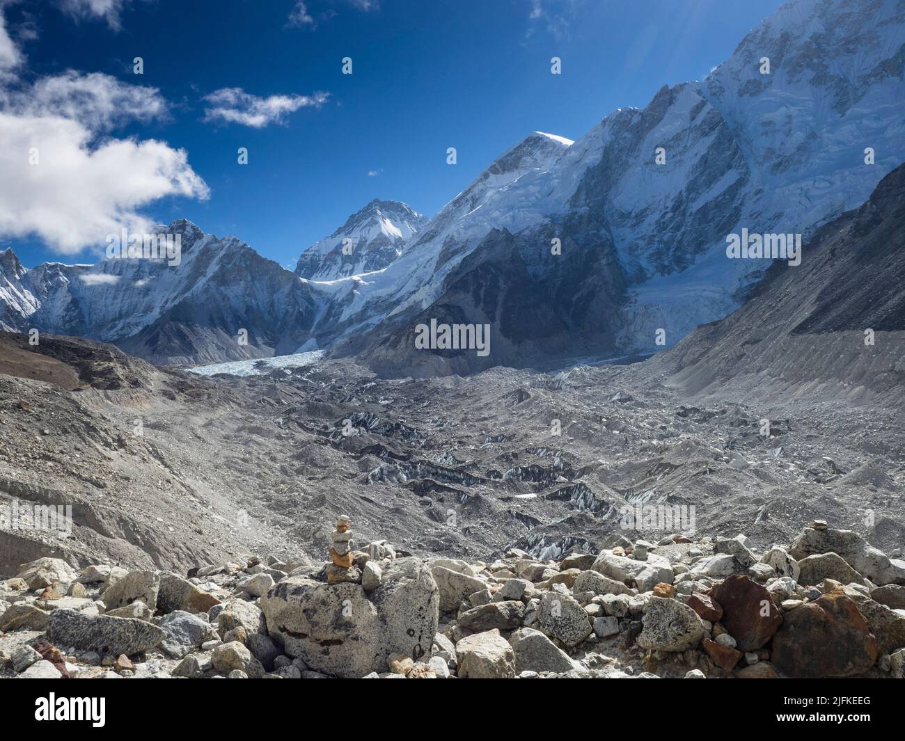Cairn auf dem Everest Base Camp Treck auf der Moräne über dem Khumbu-Gletscher mit dem Khumbu-Eisbruch in der Ferne. Stockfoto