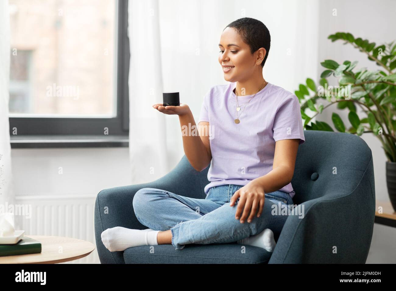 afroamerikanische Frau mit intelligentem Lautsprecher zu Hause Stockfoto