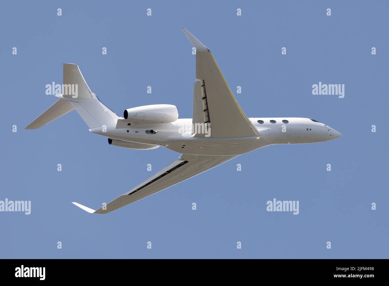Weißes Business-Flugzeug auf blauem Skyt-Abfahrtflughafen. Stockfoto