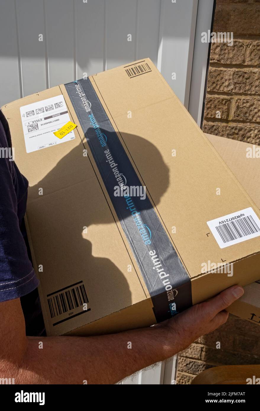 Zustellfahrer Mann Person Holding Tragen Lieferung Online-Shopping Amazon prime box Boxen Pakete Paket England Vereinigtes Königreich Großbritannien Stockfoto