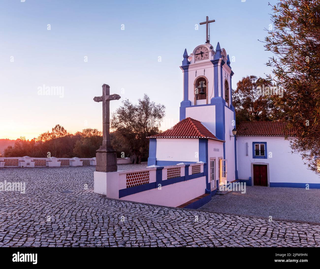 Teilansicht, bei Sonnenuntergang, der Ermida Nossa Senhora do Castelo in Coruche, Portugal, mit Hervorhebung des Glockenturms. Stockfoto