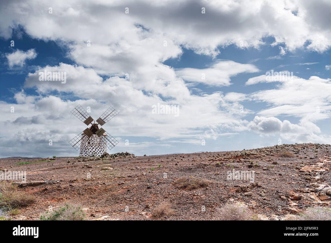 Alte Windmühle auf Fuerteventura, Kanarische Inseln, gegen blauen Himmel mit Wolken Stockfoto