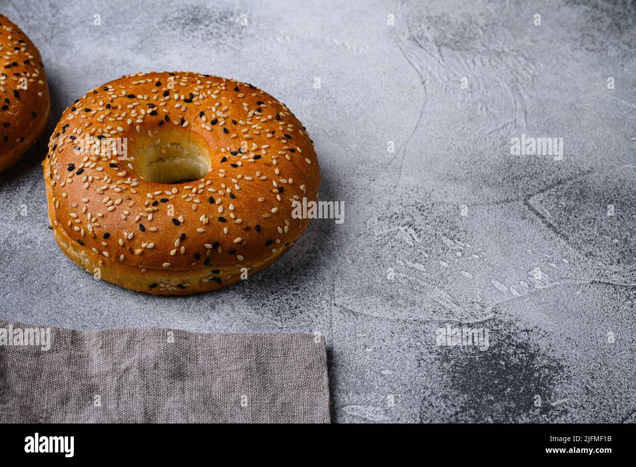 Frisches Sesam Bagel Set, auf grauem Steintisch-Hintergrund, mit Platz für Text Stockfoto