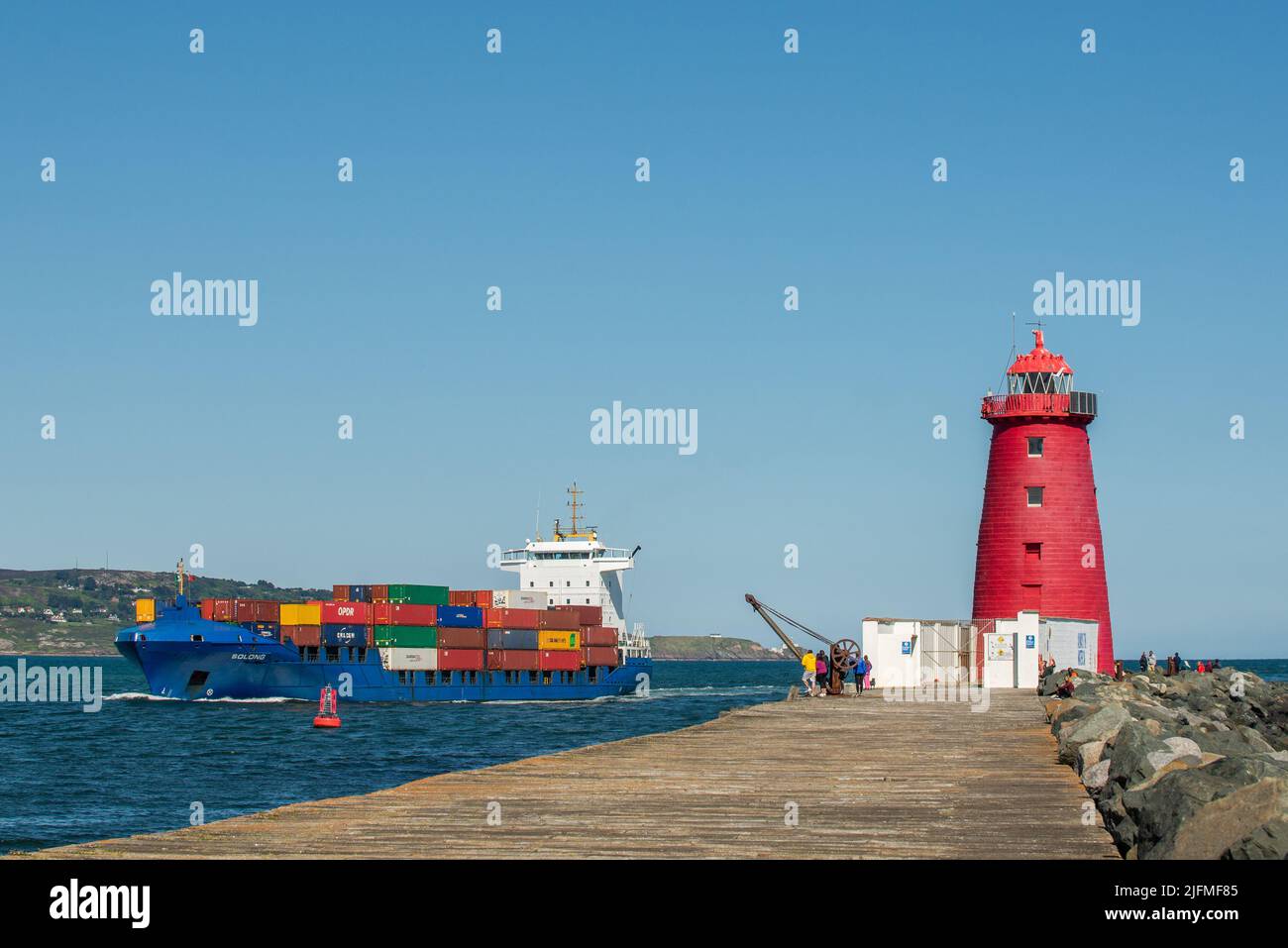 Das Containerschiff „Solong“ passiert den Leuchtturm Poolbeg im Hafen von Dublin, Dublin, Irland. Stockfoto