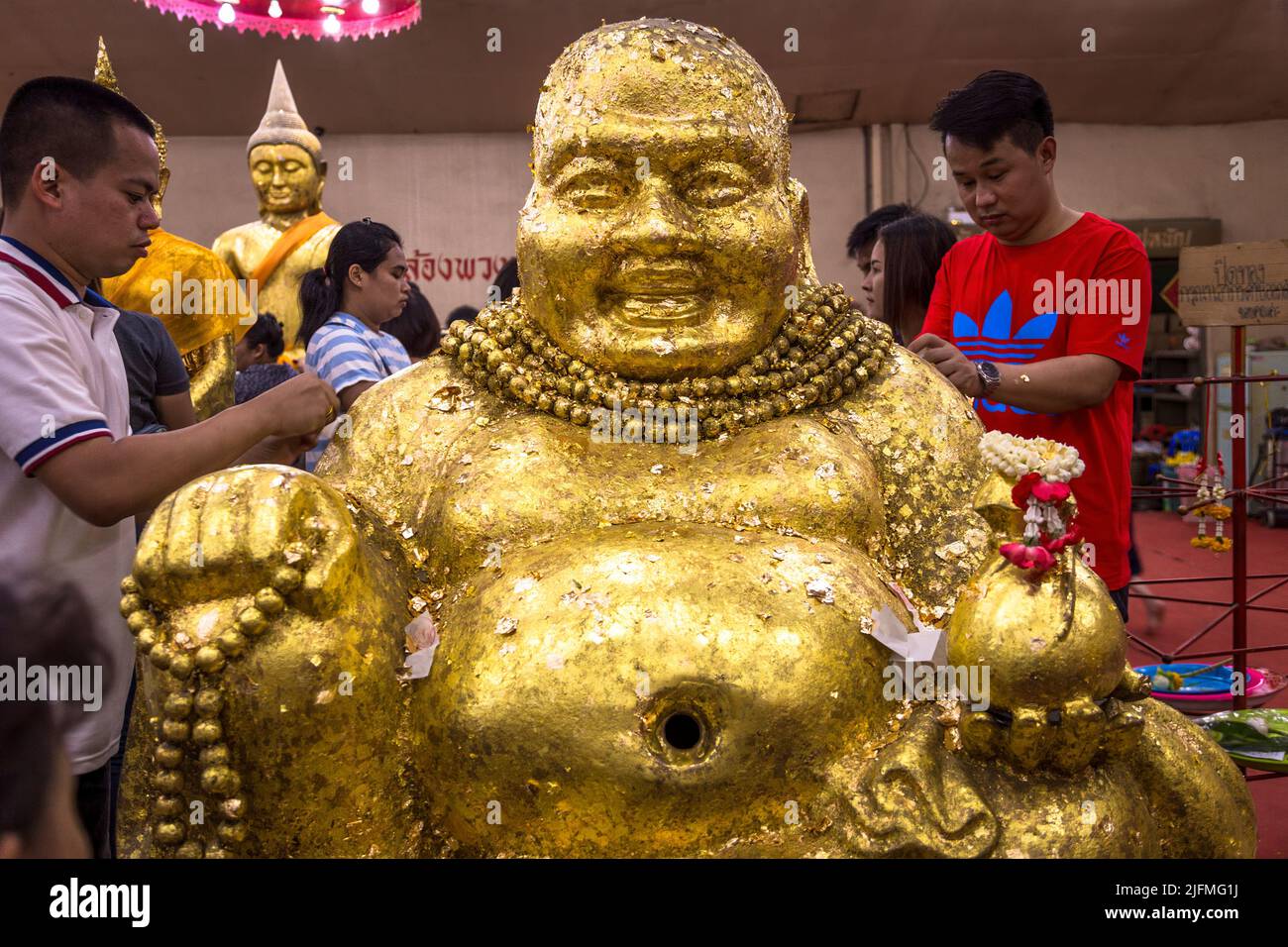 Fat Buddha mit Goldflecken gespendet von den Tempelbesuchern in Bangkok, Thailand. Großer fetter buddha Stockfoto