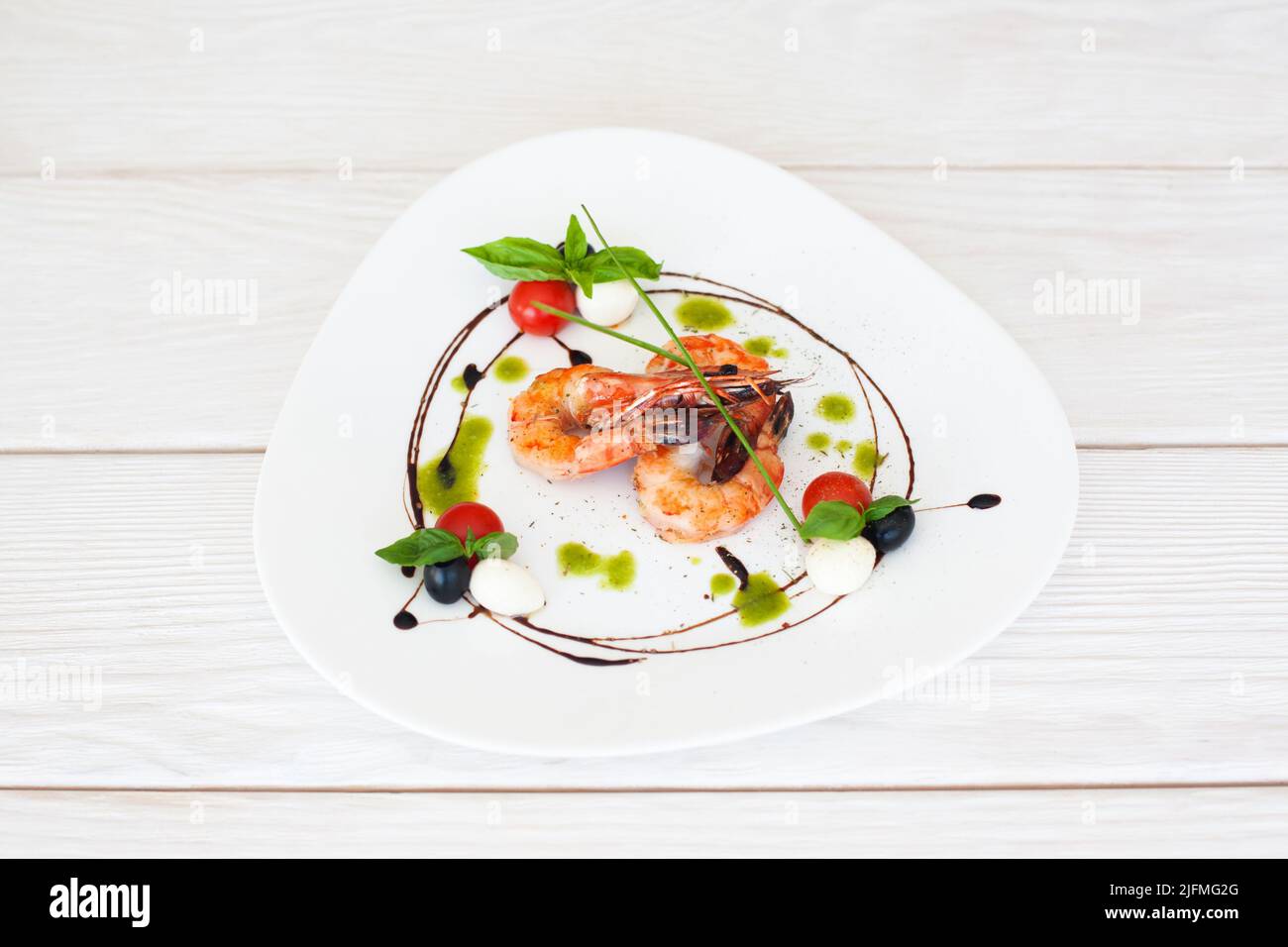 Platte mit gebratenen Garnelen auf weißem Holzhintergrund Stockfoto