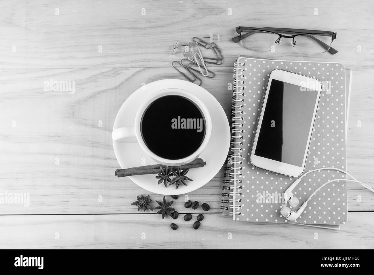 Smartphone, Kaffee, Gläser und Notizbuch auf Holztischhintergrund. Geschäftskonzept Stockfoto