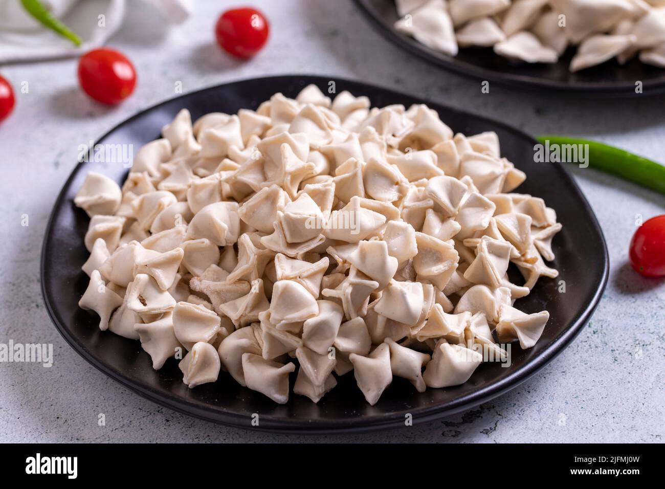 Gefrorene Ravioli auf Steinboden. Gefüllte Ravioli in der Mitte. Türkische Ravioli. Traditionelle Köstlichkeiten der Weltküche. Nahaufnahme. Stockfoto