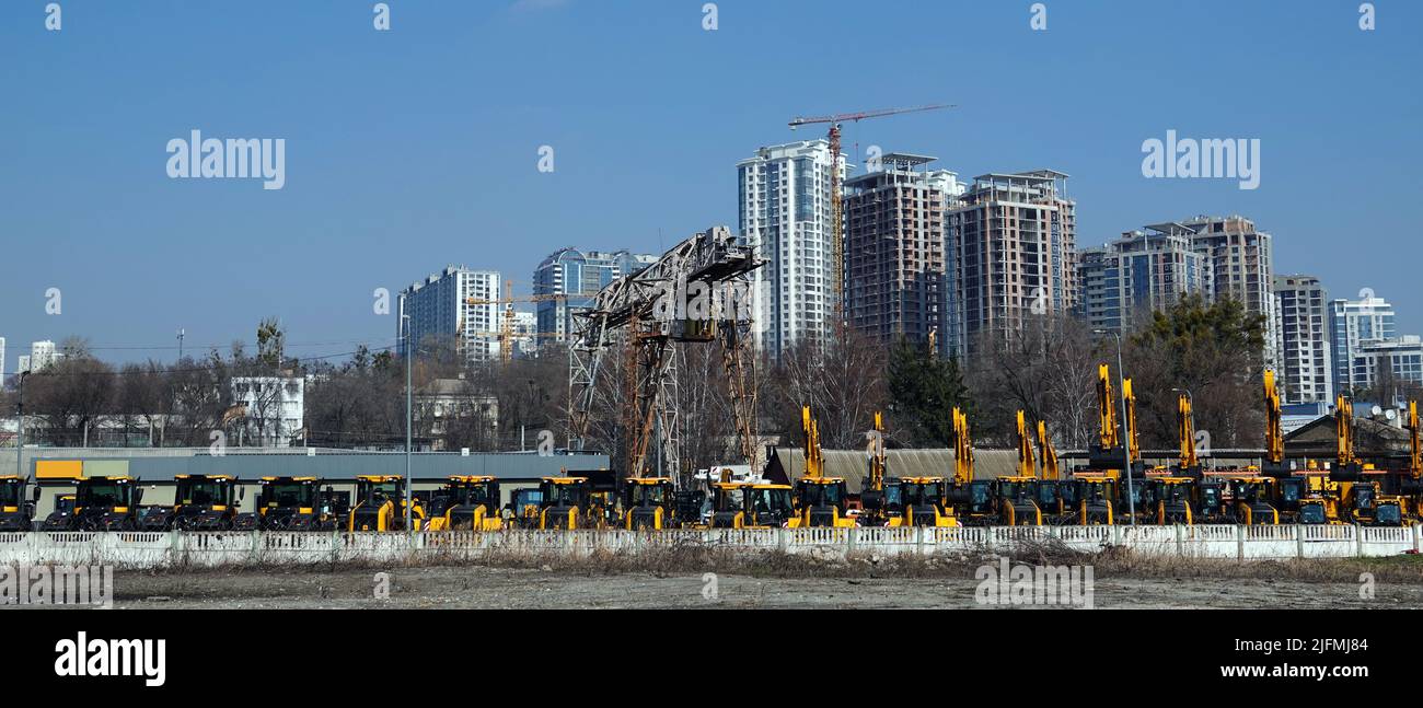 Kiew, Ukraine 18. März 2020: Traktoren und Bagger zum Verkauf auf dem Hintergrund der Häuser im Bau Stockfoto