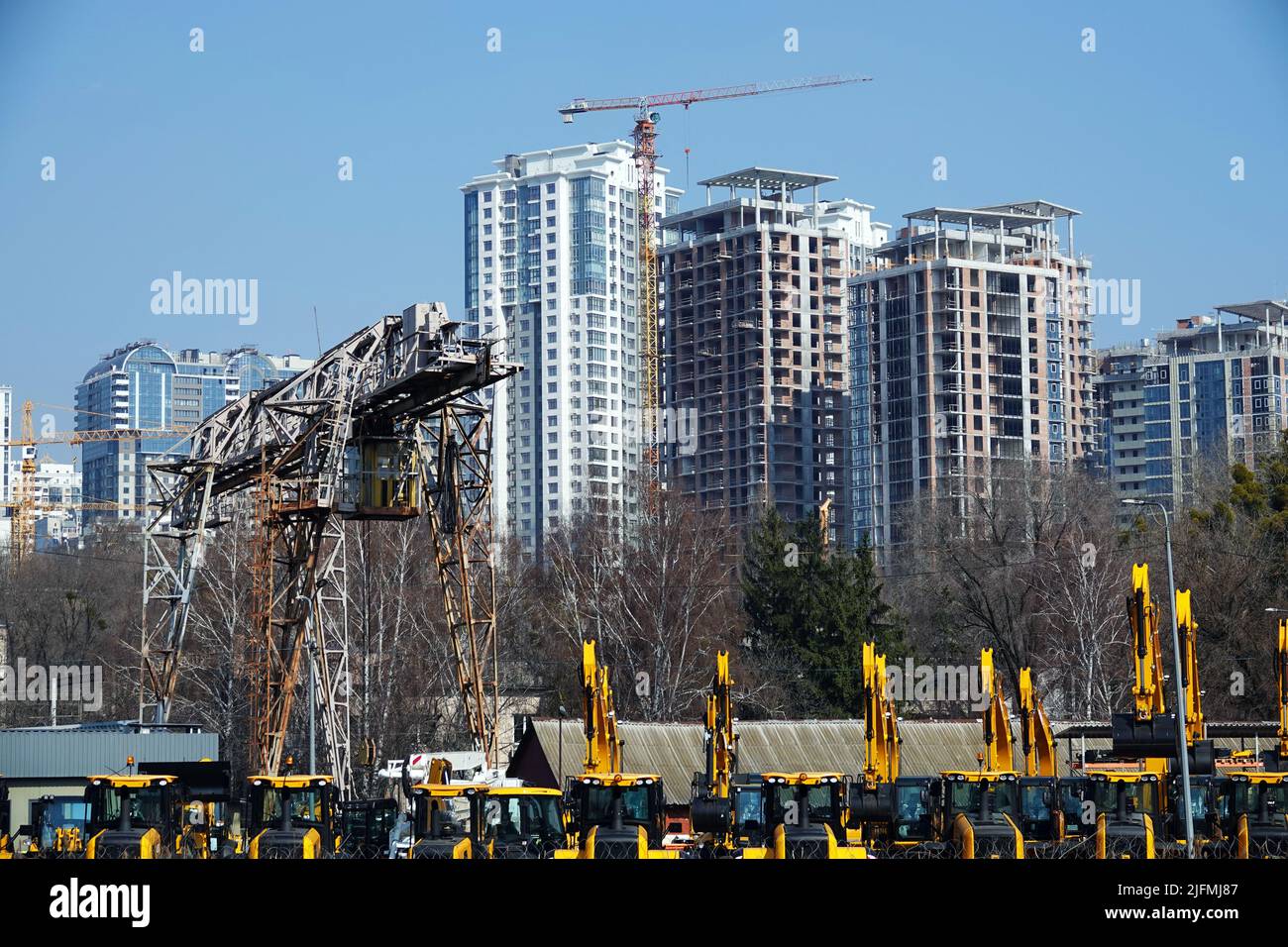 Kiew, Ukraine 18. März 2020: Traktoren und Bagger zum Verkauf auf dem Hintergrund der Häuser im Bau Stockfoto