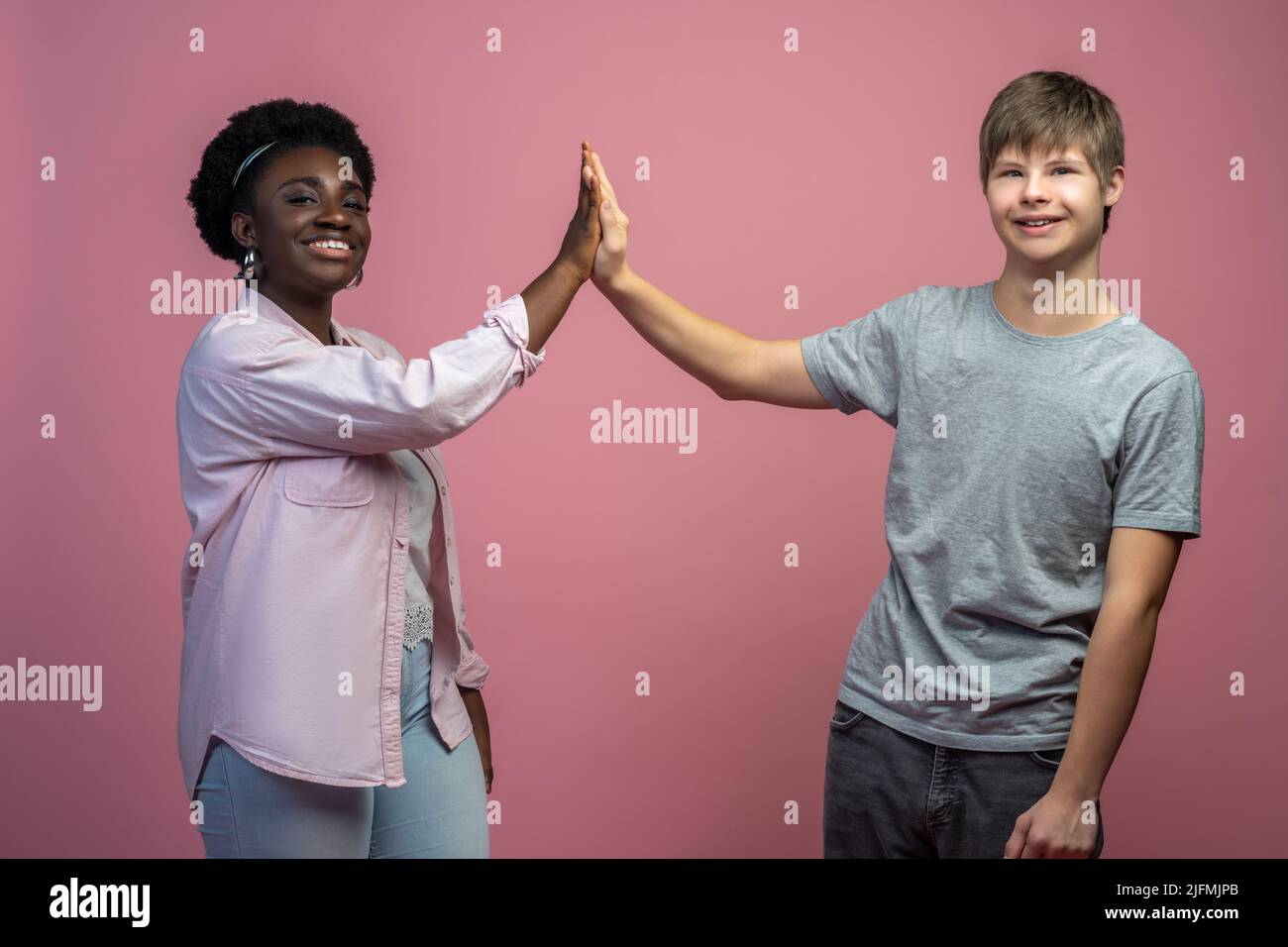 Frau und Mann berühren sich mit Handflächen und blicken auf die Kamera Stockfoto