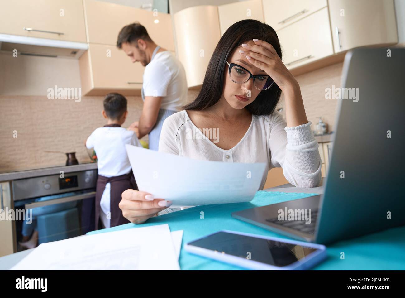 Gestresste Dame, die zu Hause mit Arbeitsdokumenten zu tun hat Stockfoto
