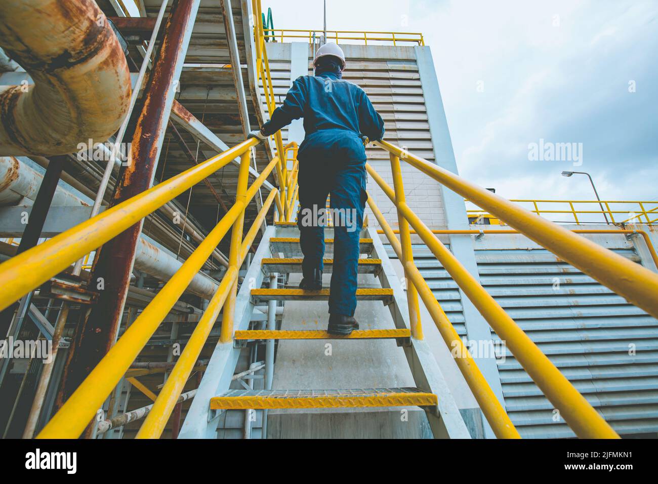 Mann, der die Treppeninspektion in der Fabrik hochgeht Stockfoto