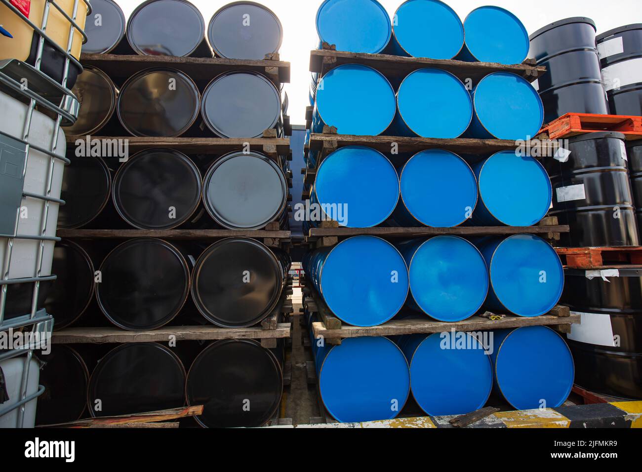 Ölfässer mit blauen und schwarzen oder chemischen Fässern horizontal gestapelt Stockfoto