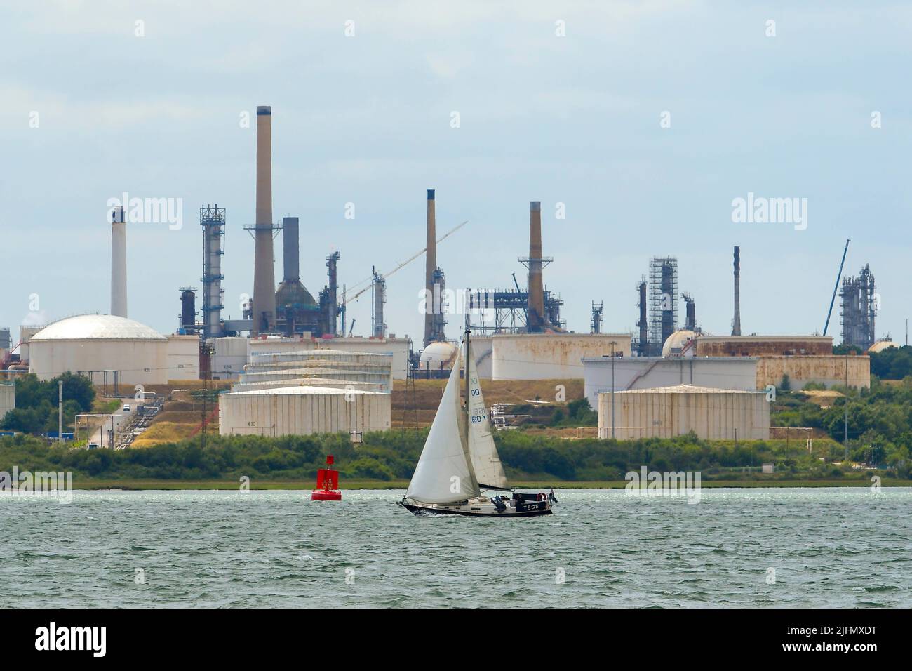 Fawley, Hampshire, Großbritannien. 4.. Juli 2022. Allgemeine Ansicht der Ölraffinerie Fawley, die am Ufer des Southampton Water in der Nähe von Southampton in Hampshire liegt und sich im Besitz der ESSO Petroleum Company befindet. Abgebildet ist eine Yacht, die in Richtung Solent an der Raffinerie vorbei segelt. Bildnachweis: Graham Hunt/Alamy Live News Stockfoto