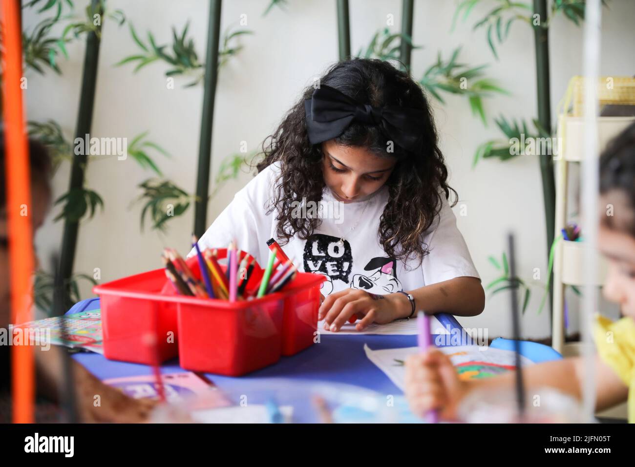 Kleines Mädchen Färbung auf Malpapier und Spaß an der Kunst Klassenzimmer Tisch. Ein Kind, das zu Hause oder im Kindergarten Farbe lernt. Stockfoto