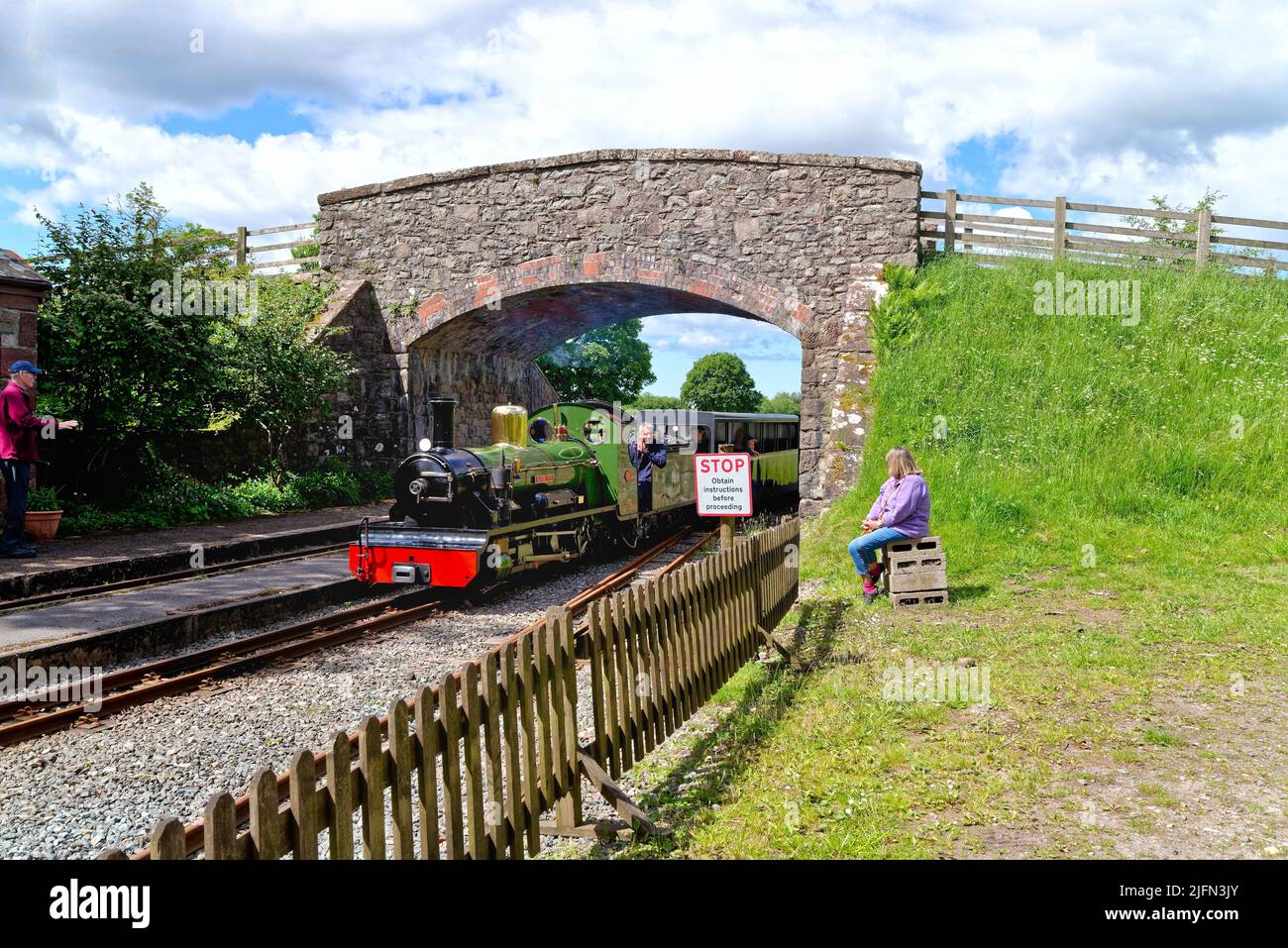 Ein Dampfzug der Ravenglass und Eskdale Heritage Railway, der an einem Sommertag durch die Irton Station Eskdale Green fährt Stockfoto