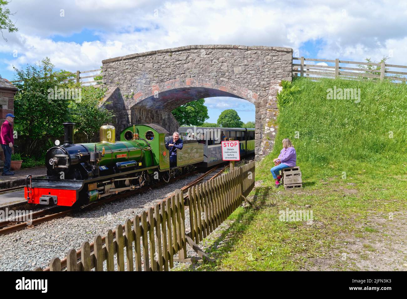 Ein Dampfzug der Ravenglass und Eskdale Heritage Railway, der an einem Sommertag durch die Irton Station Eskdale Green fährt Stockfoto