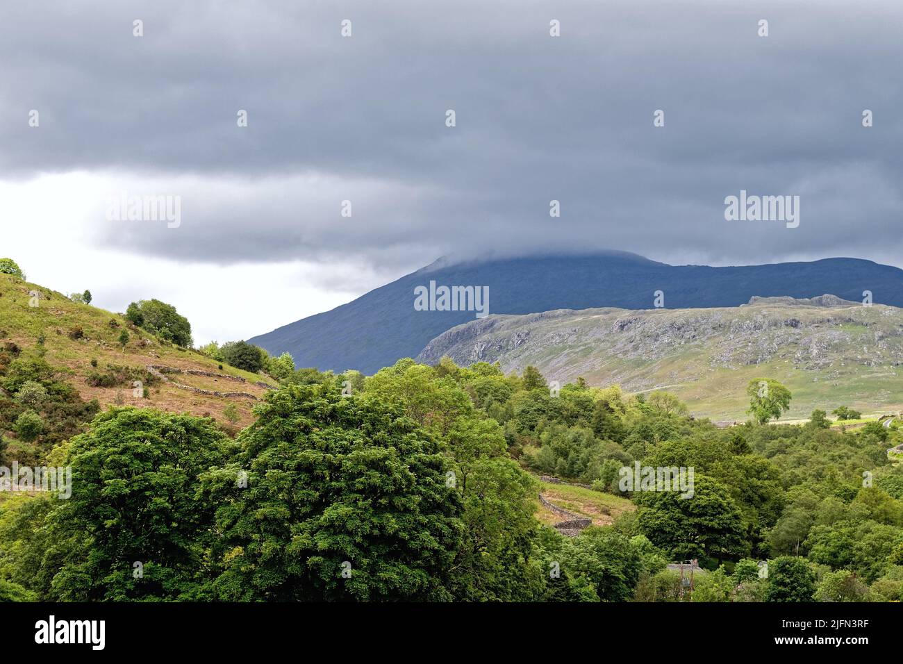 Die Scafell-Gebirgskette mit Sturmwolken dominiert an einem Sommertag die Skyline von Boot, Eskdale, Lake District Cumbria England Stockfoto