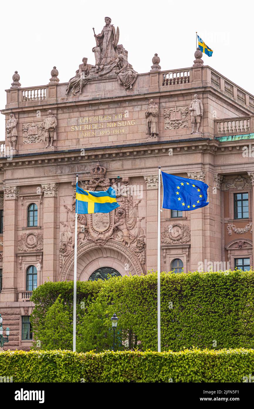 Die schwedische Nationalflagge und die Flagge der Europäischen Union, die vor dem Parlamentsgebäude (Riksdag) in Stockholm, Schweden, fliegt Stockfoto