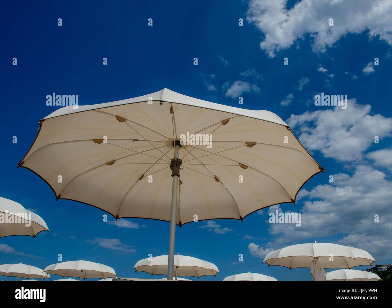 Weiße Sonnenschirme öffnen sich an einem schönen sonnigen Tag Stockfoto