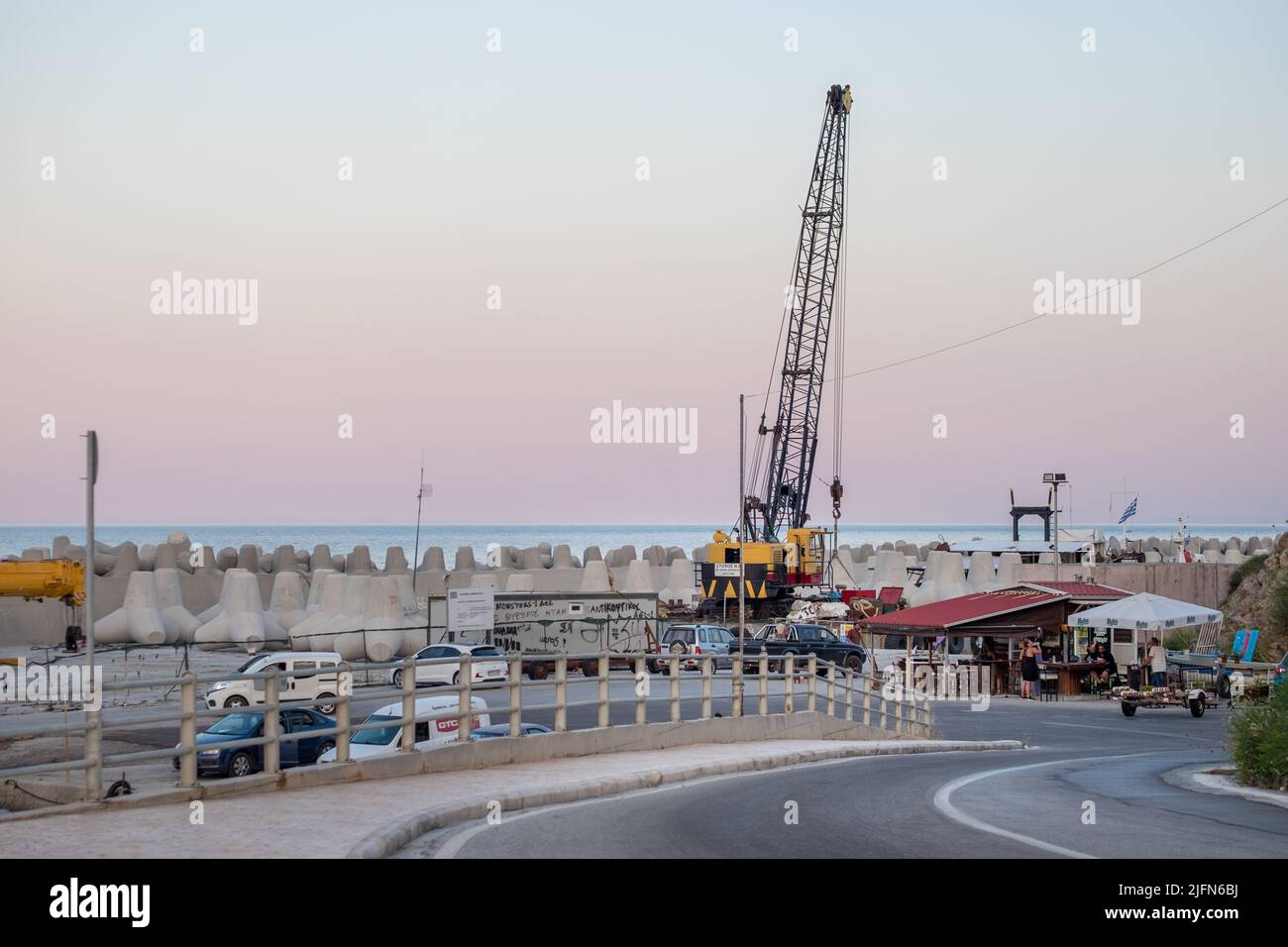 Kaffeebar, Kranwagen und Wellenbrecher in einem Hafen Stockfoto