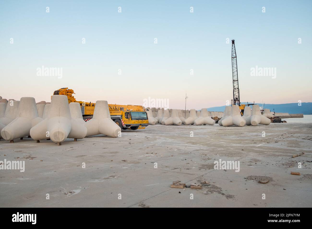 Kranwagen und Wellenbrecher in einem Hafen Stockfoto