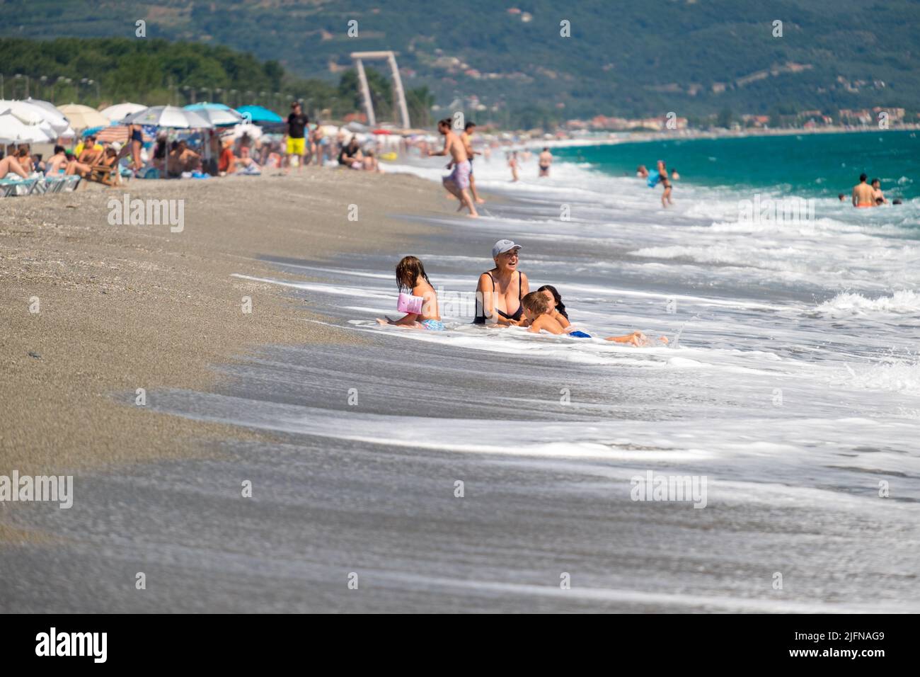 Leute, die Spaß mit den Wellen am Strand haben Stockfoto