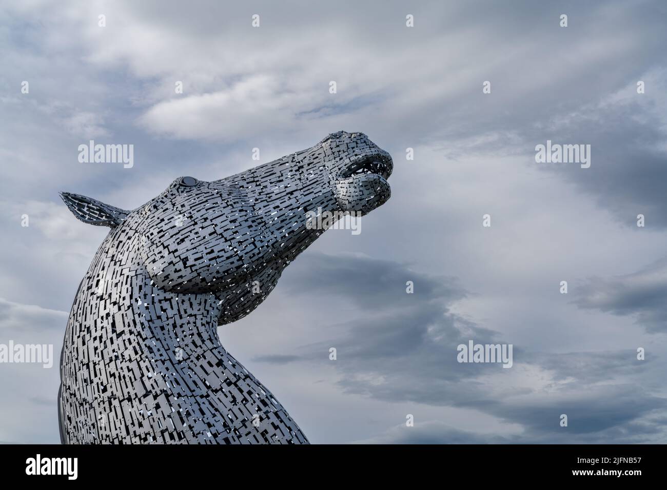 Falkirk, Vereinigtes Königreich - 20. Juni 2022: Eine der Kelpies-Pferdekopfskulpturen mit einem ausdrucksstarken, langbelichteten Himmel dahinter Stockfoto