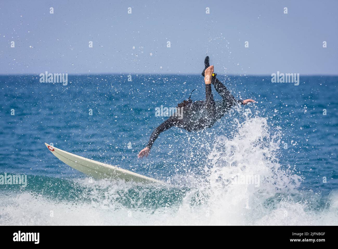 Ein Surfer, der in Jeffreys Bay, Südafrika, auf einer Punktebrecherwelle reitet und abwischend ist Stockfoto