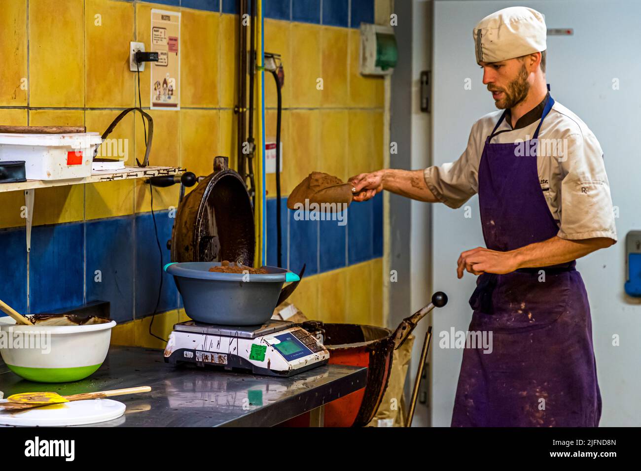 Ein Mitarbeiter der Chocolaterie Frigoulette wiegt Zutaten für die Malakoff-Praline, den Bestseller der Manufaktur in Beaufort-sur-Gervanne, Drôme, Frankreich. Frigoulette verwendet keine tierischen Fette wie Milch, Sahne oder Butter und kein Palmöl. Stattdessen verwendet es 68 Prozent Kakao und echte Kakaobutter von der Insel São Tomé. Stockfoto